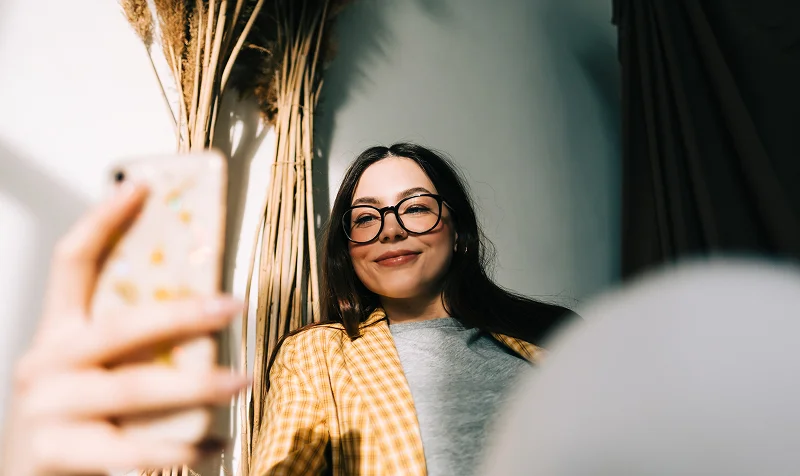 Young happy woman holding smartphone